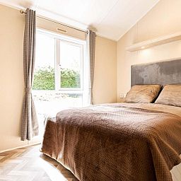 Gezellige slaapkamer in Sky 4 personen vakantiehuis, Ede, Veluwe. Ontspan in deze sfeervolle ruimte met veel natuurlijk licht.