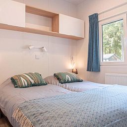 Gezellige slaapkamer van Module Flat Roof 4 personen in Ede, Veluwe, Gelderland, met grote ramen en comfortabel bed.