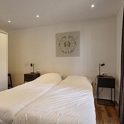 Hoofdslaapkamer van Module Wood 5 personen vakantiehuis in Ede Veluwe met tweepersoonsbed en moderne inrichting.