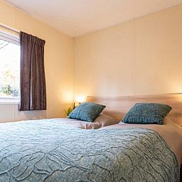 Komfortables Schlafzimmer in einem Ferienhaus fuer 6 Personen in Ede, Veluwe, Gelderland mit grossem Fenster.