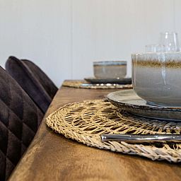 Cozy dining area in Luna vacation home, Ede, Veluwe, with set table.