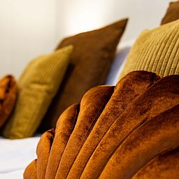 Comfortable bedroom in Luna vacation home, Ede, Veluwe, with colorful pillows.