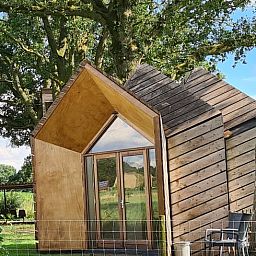 Ferienhaus in Ede, Veluwe, mit rustikaler Holzausstattung und natuerlicher Umgebung.
