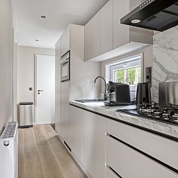 Terrasse des Ferienhauses Wilgenhof in Ede, Veluwe, mit Liegesthlen und grner Umgebung.