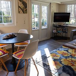 Dining area in Holiday home in Emst, Gelderland, with modern chairs and table.