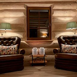 Gemuetliche Sitzecke im Ferienhaus in Emst, Veluwe. Bequeme Ledersessel und stimmungsvolle Beleuchtung in diesem gemuetlichen Ferienhaus.