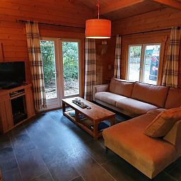 Gemuetliches Wohnzimmer des Ferienhauses in Ermelo, Veluwe, mit Blick auf die Natur.