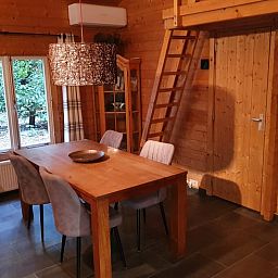 Essecke im Ferienhaus in Ermelo, Veluwe, mit Holzinterieur und moderner Beleuchtung.