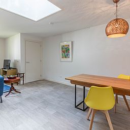 Geniet van de zonnige patio van vakantiehuis DG1560 in Ermelo, Veluwe, omgeven door weelderige natuur en rustgevende groene heggen.