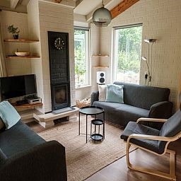 Cozy living room in a cottage in Ermelo, Veluwe, with comfortable sofas and views of the green countryside of Gelderland.