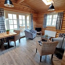 Gemuetliches Wohnzimmer im Cottage in Ermelo, Veluwe, Gelderland mit Holzinterieur und Blick auf die Terrasse.