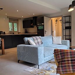 Gezellige woonkamer in Vakantiehuis in Hoenderloo, Veluwe, met moderne keuken en comfortabele zithoek in Gelderland.