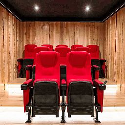 Privates Kino im Ferienhaus Specht, Hoenderloo, Veluwe, Gelderland mit roten Sitzen.