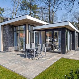 Spacious terrace at Vakantiewoning Hertenhoeve comfort in Hoenderloo, Veluwe. Ideal for outdoor dining and enjoying the surroundings.