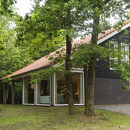 Dining room in Miggelenberg bungalow, Hoenderloo, Veluwe, Gelderland, with large wooden table.