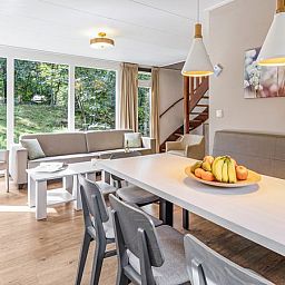 Eetkamer met uitzicht op natuur in Miggelenberg 8-persoons bungalow 8C, Hoenderloo, Veluwe.