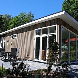 Side view of Holiday home Heidehoeve comfort with spacious outdoor area in Hoenderloo, Veluwe, Gelderland.