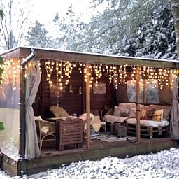 Knusse binnenruimte van Vakantiehuisje in Garderen met comfortabele zithoek en winterse Veluwe-omgeving.