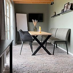 Dining room in Holiday Home in 't Harde, Veluwe, with modern furnishings and lots of natural light.