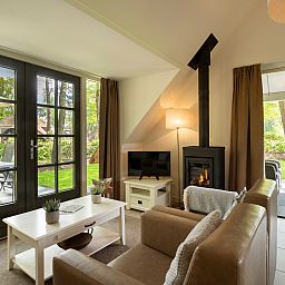 Cozy living room with fireplace in Holiday home Sprielderbosch 12 'De Kuifmees', vacation home in Putten, Veluwe.
