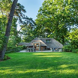 Blick auf den gruenen Garten des Ferienhauses Sprielderbosch 23 De Zwijnenstal, ein rustikales Ferienhaus in der Veluwe.