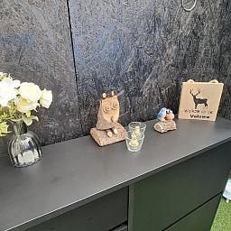 Decorative corner of Chalet Relax in Putten, Veluwe, Gelderland, with wooden ornaments and a welcome sign.