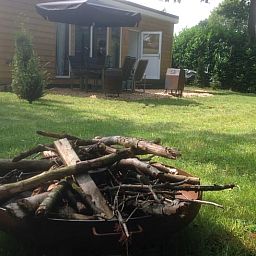Entspannen Sie sich auf der Terrasse des Ferienhauses in Voorthuizen, Veluwe, Gelderland, umgeben von gruener Natur und ruhiger Umgebung.
