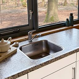 Keukenraam met uitzicht op de natuur in Vakantiehuis in Voorthuizen, Veluwe. Geniet van de groene omgeving tijdens het koken.