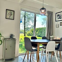 Gemuetliches Esszimmer im Ferienhaus in Voorthuizen, Veluwe, mit Blick auf die gruene Natur und stimmungsvollem Dekor.