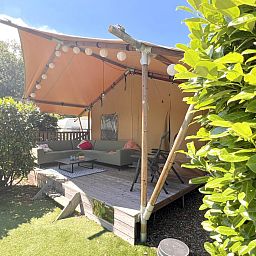 Geniet van de ontspannen sfeer op de veranda van tenthuis Libelle in Hulshorst, Veluwe. Ontdek luxe glamping in de prachtige Gelderse natuur.