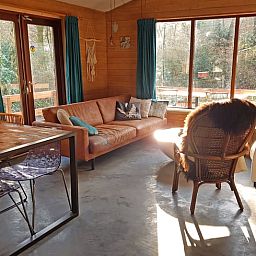 Aussenbereich von Cottage in Otterlo, Ferienhaus in Veluwe, Gelderland mit gruenem Garten und Haengematte.