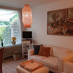 Gezellige woonkamer in Vakantiehuis in Otterlo, Veluwe, met comfortabele zitruimte en raam met uitzicht.