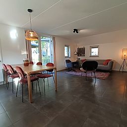 Ruime eet- en woonkamer in Vakantiehuis Geheim van Otterlo 6 in Otterlo, Veluwe, Gelderland met veel lichtinval.