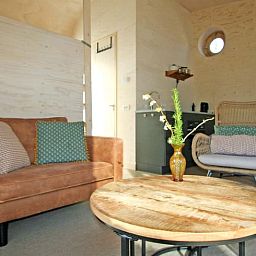 Gezellige woonkamer in Vakantiehuis in Otterlo, Veluwe, Gelderland met comfortabele zithoek en houten interieur.
