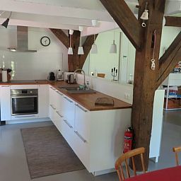 Gezellige keuken in Vakantiehuis in Epe, Veluwe, Gelderland, met moderne apparatuur en rustieke houten balken voor een sfeervol verblijf.