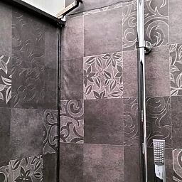 Stijlvolle badkamer van Vakantiehuis in Epe, Veluwe, Gelderland met moderne douche en elegant tegelwerk.