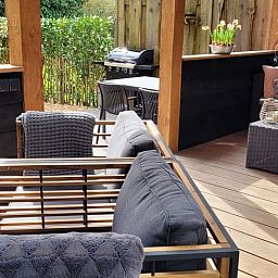 Enjoy the cozy veranda of Holiday Home in Epe in Veluwe, Gelderland, with comfortable seating areas and green surroundings.