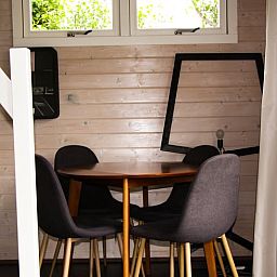 Gemuetlicher Innenbereich des Ferienhauses in Epe, Veluwe, Gelderland, mit Holzwaenden und moderner Essgruppe fuer einen entspannten Aufenthalt.