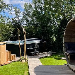 Entspannen Sie sich im Garten des Ferienhauses in Scherpenzeel, Gelderland, mit Sauna und Blick auf die Veluwe-Landschaft.