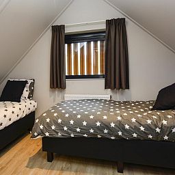 Gezellige slaapkamer in Recreatievilla 6 personen, Lunteren. Comfortabele bedden met sterrenmotief in vakantiehuis Veluwe.