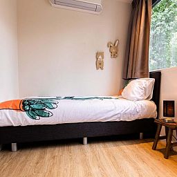 Kinderzimmer in Recreation Villa fuer 7 Personen, Lunteren, Veluwe mit Einzelbett und Dekoration.