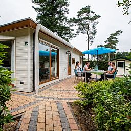 Die Veranda des Ferienhauses fuer 4 Personen in Lunteren, Veluwe, Gelderland bietet Platz fuer Mahlzeiten im Freien.