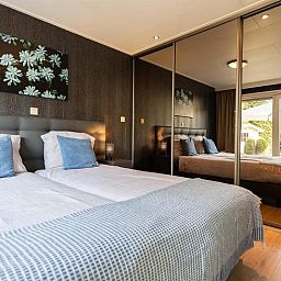 Slaapkamer in Holiday home 5 personen Wellness, Lunteren, met uitzicht op tuin, Veluwe.