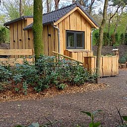 Vakantiehuisje in Uddel, Veluwe, met houten gevels en natuurlijke omgeving voor ultiem comfort.