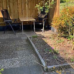 Sonnige Terrasse des Ferienhauses in Hattemerbroek, Veluwe, Gelderland, mit bequemen Sitzgelegenheiten.