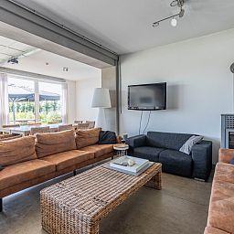 Stylish dining room in vacation home DG2126, Teuge, Veluwe, Gelderland, with wooden table, colorful flowers, and inspiring wall decor.