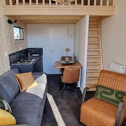 Gemuetliches Wohnzimmer des Ferienhauses in Lieren mit Kueche und Essbereich, Veluwe.