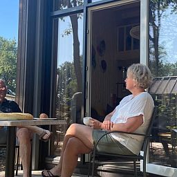 Die Gaeste geniessen ihren Kaffee auf der Veranda des Ferienhauses in Lieren, Veluwe.