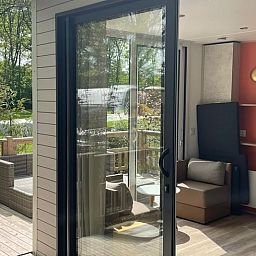 Binnenruimte van Vakantiehuis in Lieren, Veluwe, Gelderland met lichte inrichting en uitzicht op terras.