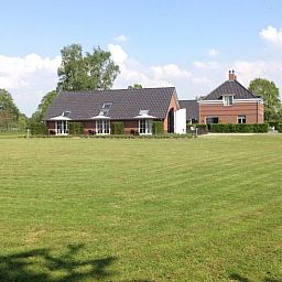 Vakantiehuisje in Eerbeek op de Veluwe, Gelderland, omgeven door een uitgestrekt groen veld en rustieke charme.